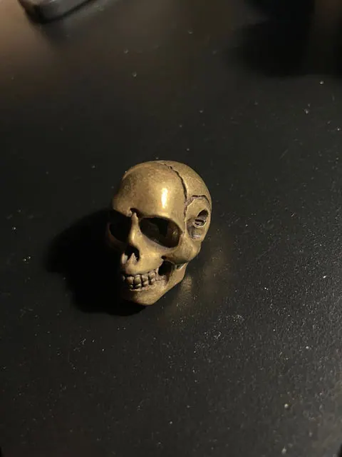 Small vintage solid Brass Skull. With holes for thread or chain